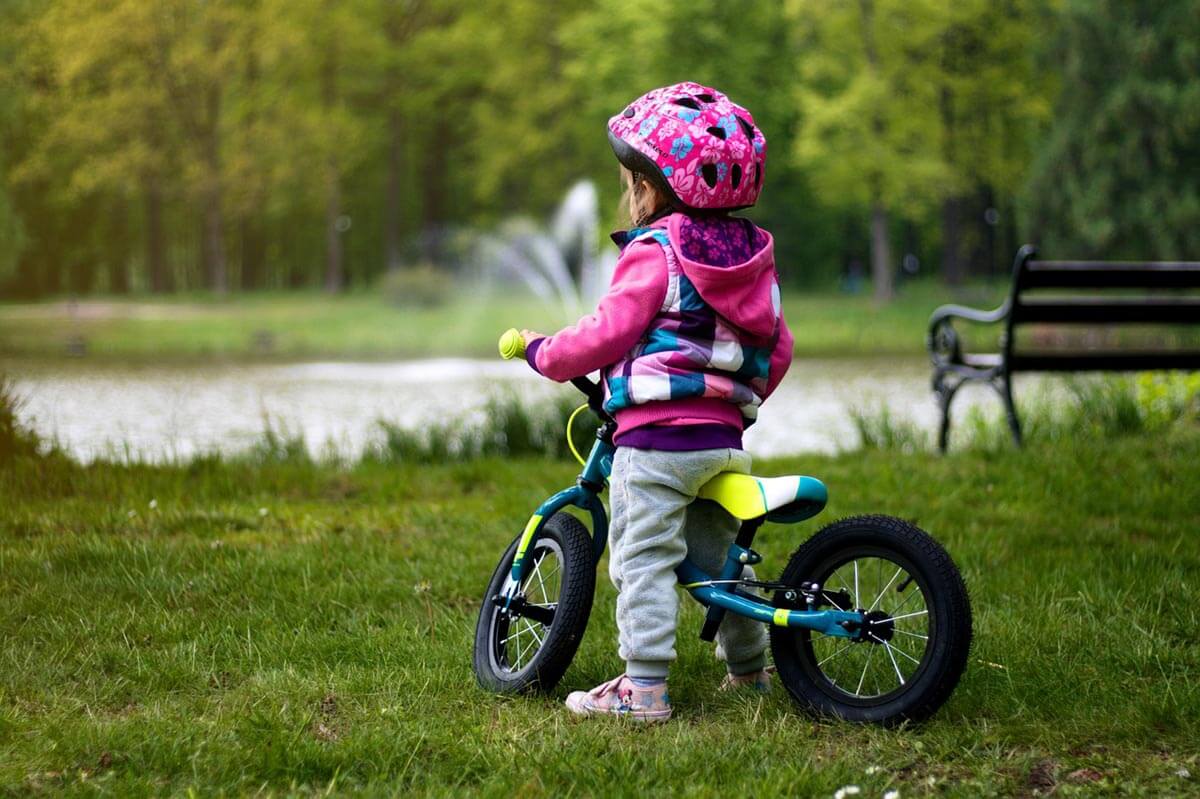 Dziecko w kasku na rowerku biegowym
